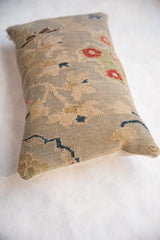 Close-up of antique Persian Sultanabad rug pillow's hand-knotted pile and beige linen backing.