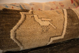 Vintage Turkish rug fragment lumbar pillow, stylized bird motif in warm earthy tones.