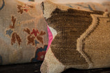 Vintage Oushak rug fragment pillow's textured pile and contrasting bright pink backing.