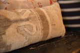 Detailed close-up of the vintage Oushak lumbar pillow's hand-knotted pile and distressed beige and brown pattern.