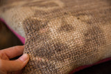 Textured, worn vintage Turkish rug fragment pile with a pop of pink backing.