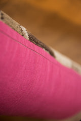 Bright pink remnant fabric backing of the vintage lumbar pillow.