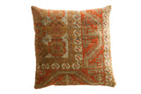 Antique Belouch rug fragment throw pillow with rust and brown geometric patterns.