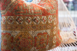 Antique Belouch rug fragment pillow, aged texture and geometric patterns in rust, brown, blue.