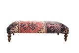 Vintage Oushak rug ottoman table with distressed geometric patterns in red, beige, charcoal.