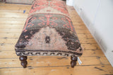 Distressed vintage Turkish rug fragment pattern, displaying faded red, beige, charcoal tones and worn texture.