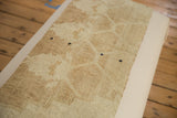 Dark snaps securing the textured tan vintage rug fragment to the canvas ottoman table.