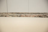Close-up on the woven edge and low-pile texture of a swappable vintage rug fragment.