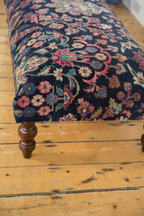 Navy and magenta floral pattern on vintage Yezd rug ottoman with carved leg.