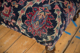 Vintage Yezd rug ottoman corner with hand-knotted navy, faded magenta, ivory curvilinear patterns and worn pile.