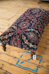 Finely hand-knotted Yezd rug fragment on ottoman, navy field, magenta and ivory floral design.