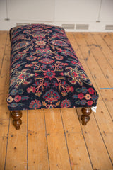 Long vintage Yezd rug ottoman featuring a navy floral top on turned wood legs.