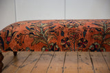 Close-up of vintage Lilihan rug fragment showing dusty rose, navy, gold floral motifs, authentic wear.
