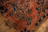 Detail of vintage Lilihan rug fragment: dusty rose ground with navy and gold floral vines.