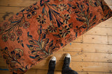 Dusty rose vintage Lilihan rug ottoman, floral vines with navy, gold, copper hues.