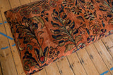 Dusty rose Persian Lilihan rug fragment with navy, gold floral vines, and visible wear.
