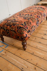 Dark stained curved wooden leg of the Vintage Persian Rug Ottoman.