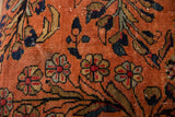 Hand-knotted Lilihan rug fragment close-up, dusty rose field, navy floral motifs, wear visible.