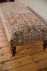 Textured top of a Vintage Persian Rug Ottoman Coffee Table with ornate muted patterns.
