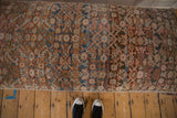Overhead view of vintage Persian rug fragment ottoman, showing intricate pattern and muted hues.