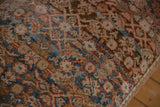 Surface of Vintage Persian Rug Ottoman with intricate blue, rust, and beige hand-knotted patterns.