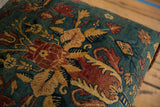 Plush texture of an antique Persian rug ottoman with cochineal red and sand floral motifs.