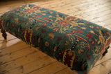 Sheen and texture of an antique Persian rug ottoman corner with floral and chicken designs.