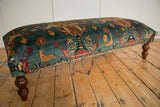 Antique Persian rug ottoman with pictorial upholstery showing chickens, trees, and turned wooden legs.