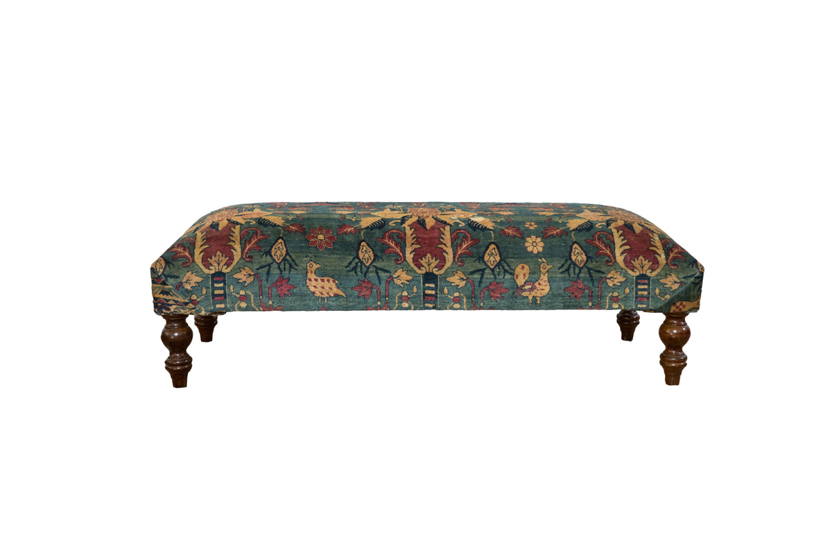 Antique Persian rug ottoman with pictorial chickens in sapphire blue and red, set on dark curved legs.