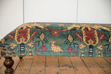 Side profile of the antique Persian rug ottoman featuring a chicken and floral motif.
