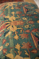 Detailed view of pictorial chicken and floral motifs on the antique Persian rug ottoman.