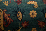 Detailed view of the antique rug's chicken and floral motifs in red and gold on a sapphire blue pile.