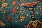 Close-up texture of the antique rug upholstery with floral motifs in red and sand on a sapphire blue field.