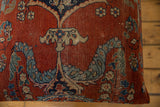 Close view of the antique rug's low pile, showing wear and floral motifs in red and blue.