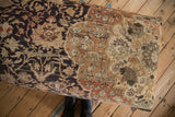 Overhead view of the vintage rug ottoman's top showing its charcoal and terracotta patterns.