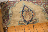 Antique Kerman rug fragment's curvilinear design in sand, blue, aubergine, pistachio green hues.