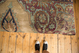 Detail of antique Persian Kerman rug fragment; patinaed sand ground, aubergine and pistachio curvilinear design.