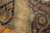 Rich aubergine, dusty blue, and sand curvilinear floral patterns on worn antique Kerman fragment.