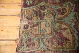 Close-up of antique Kerman fragment, featuring floral vines in sand, aubergine, and dusty blue.
