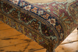 Curved antique Kerman rug ottoman side, detailed floral pattern in dusty blue, aubergine.