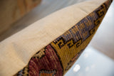 Side of vintage Oushak rug fragment pillow with vibrant hand-knotted pattern.