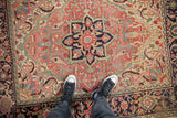 A standing view over a vintage Heriz rug, highlighting the textured weave and central medallion.