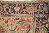 Detail of a vintage Heriz rug's Samovar border in navy blue, ruby red, and emerald green.