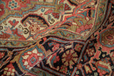Folded vintage Heriz rug revealing its hand-knotted texture and detailed serrated leaf patterns.