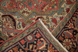 Folded corner of a vintage Heriz rug showing its hand-knotted pile and detailed Samovar border.