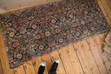Antique Persian Fereghan rug ottoman featuring navy, ivory, and terracotta floral patterns.