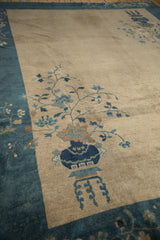 Potted plant motif with deep sapphire blue vase and copper brown flowers on ivory Peking rug.