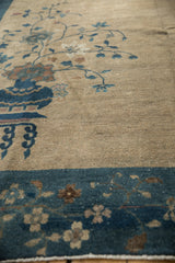 Vintage Peking carpet's deep sapphire border, ivory field, and arts and crafts floral patterns.