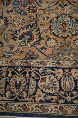 Vintage Meshed carpet detail: low pile, navy border, and bronze field with Shah Abas motif.
