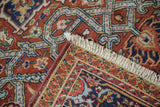 Vintage Heriz carpet's detailed geometric border, ivory fringe, and sturdy weave.